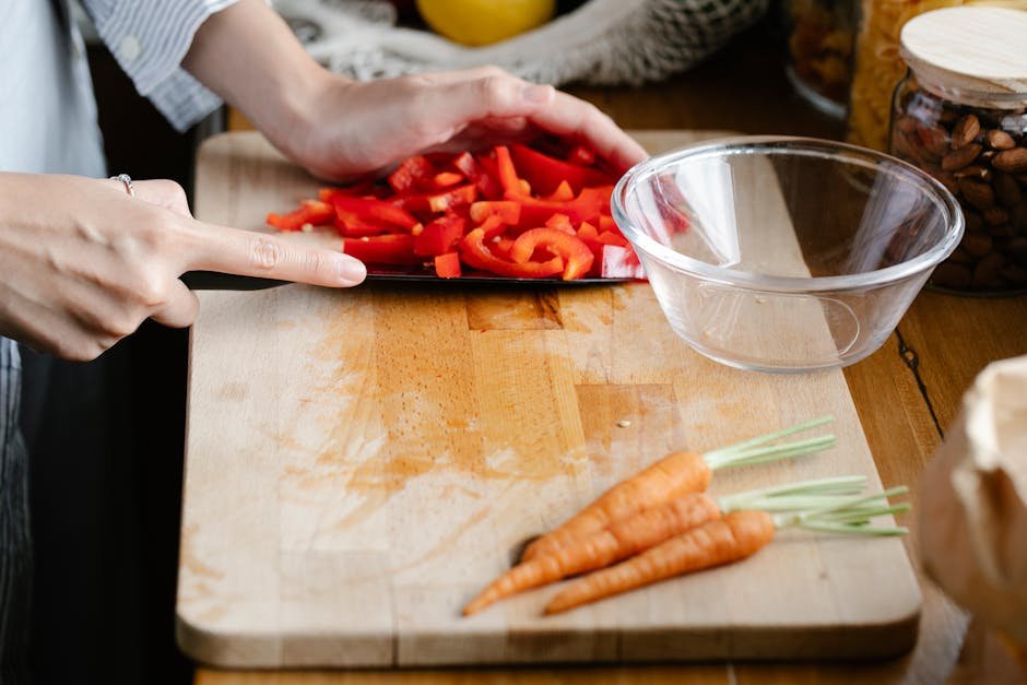 Hands preparing fresh vegetables on a cutting board, capturing the essence of healthy cooking.