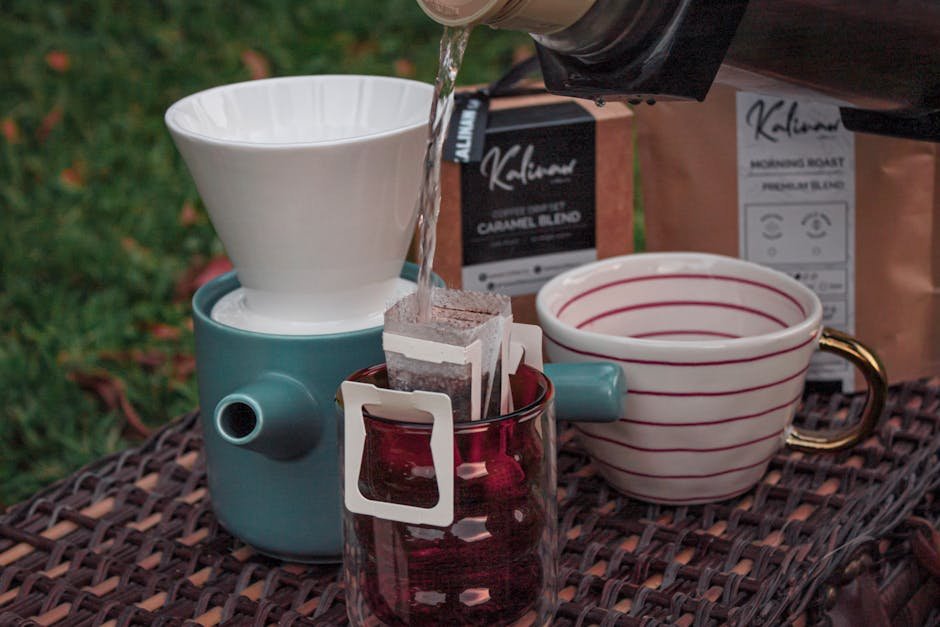 Close-up of water pouring over coffee filter on outdoor table.