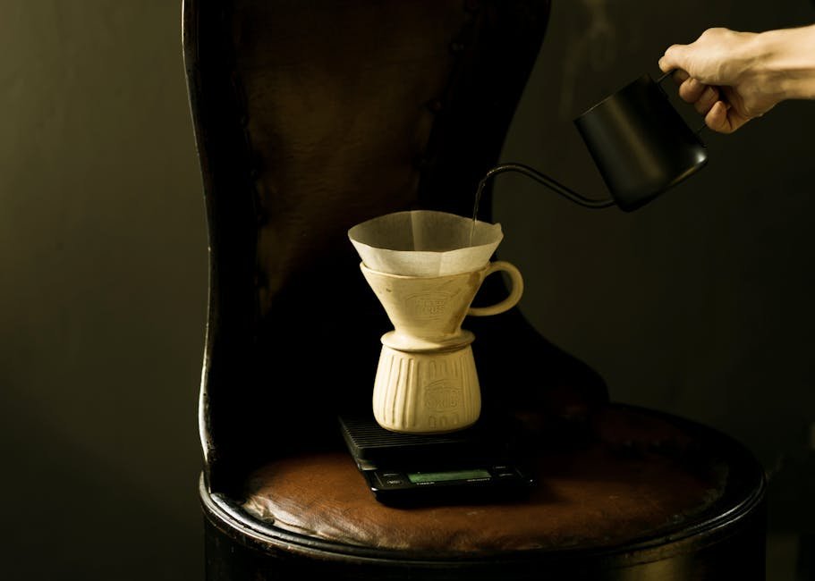 Elegant pour over coffee being made with a dripper on a sophisticated wooden chair.