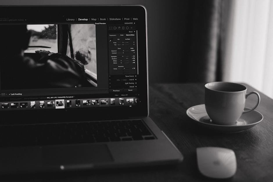 Minimalist black and white photo of a laptop with coffee. Ideal for home office themes.